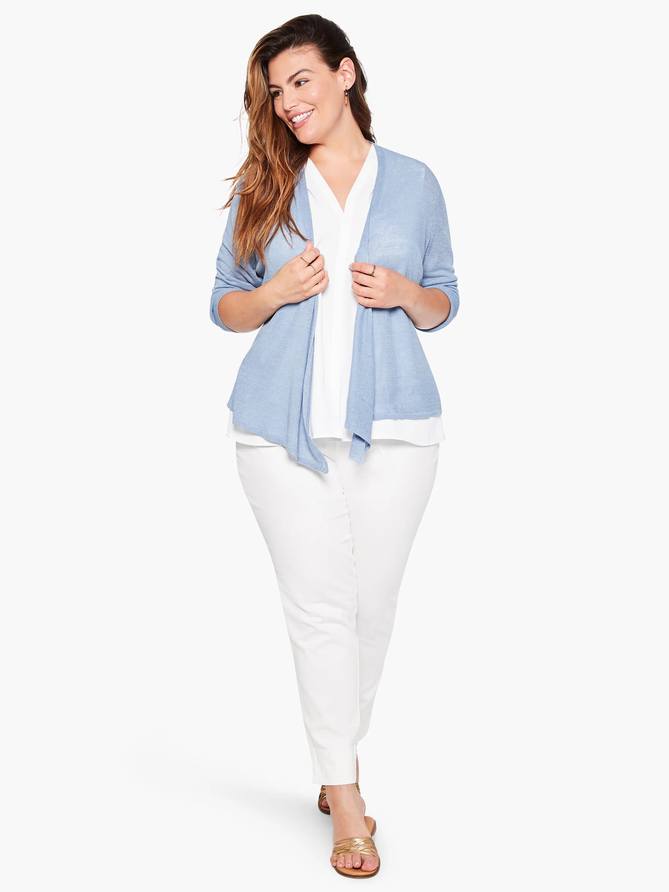 Light blue open cardigan, layered over white top.  Model wears white pants and gold sandals.