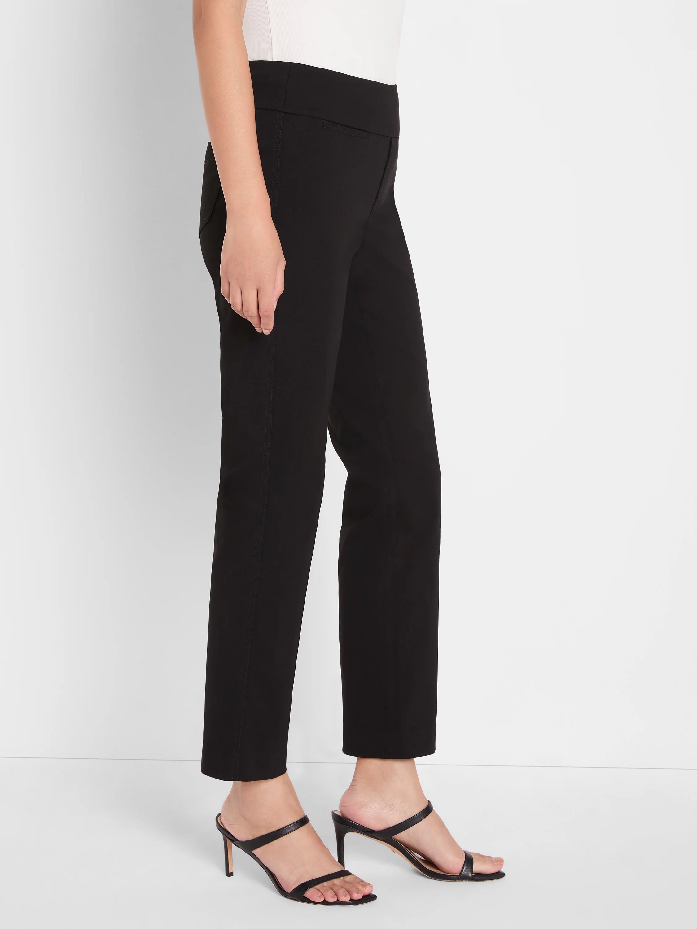 White blouse, only the top part visible and tucked into black trousers.