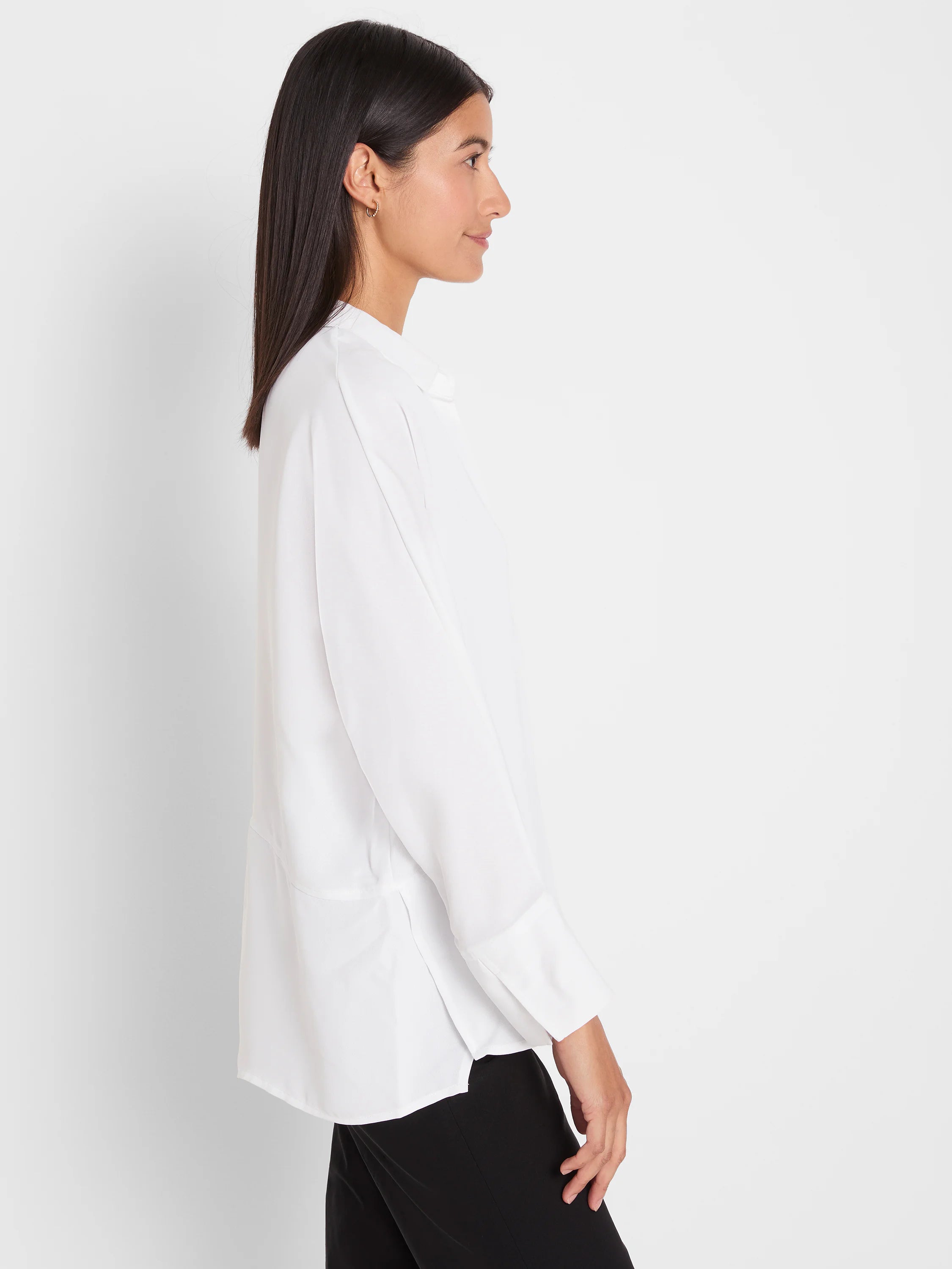 White flowing blouse with a collar, long sleeves, wide cuffs, and side slits.