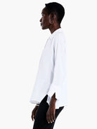 White collared, long-sleeve blouse;  loose fit, slightly longer in back.