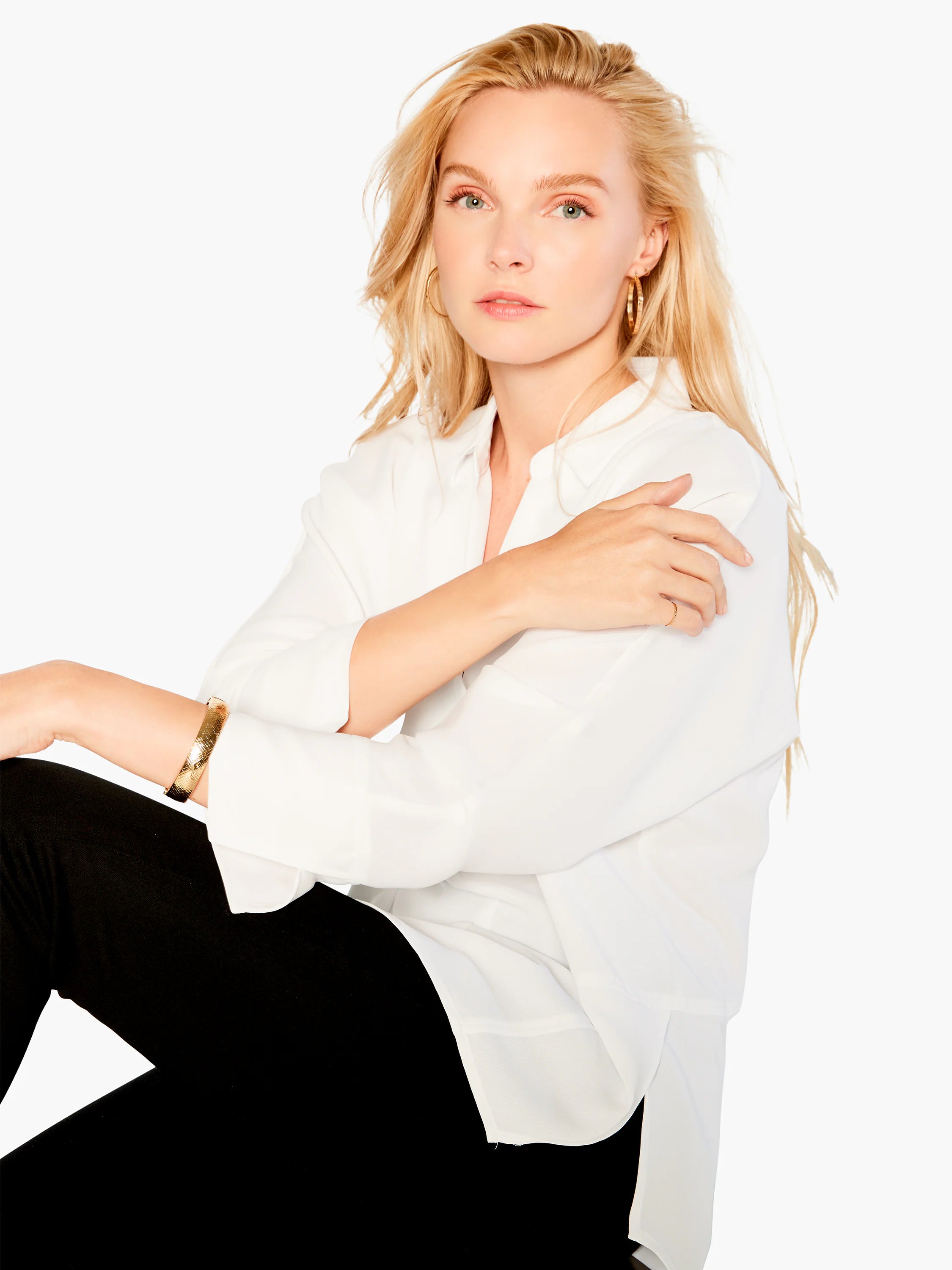 White collared blouse; long sleeves; slightly loose fit.  Model wears it with black pants.