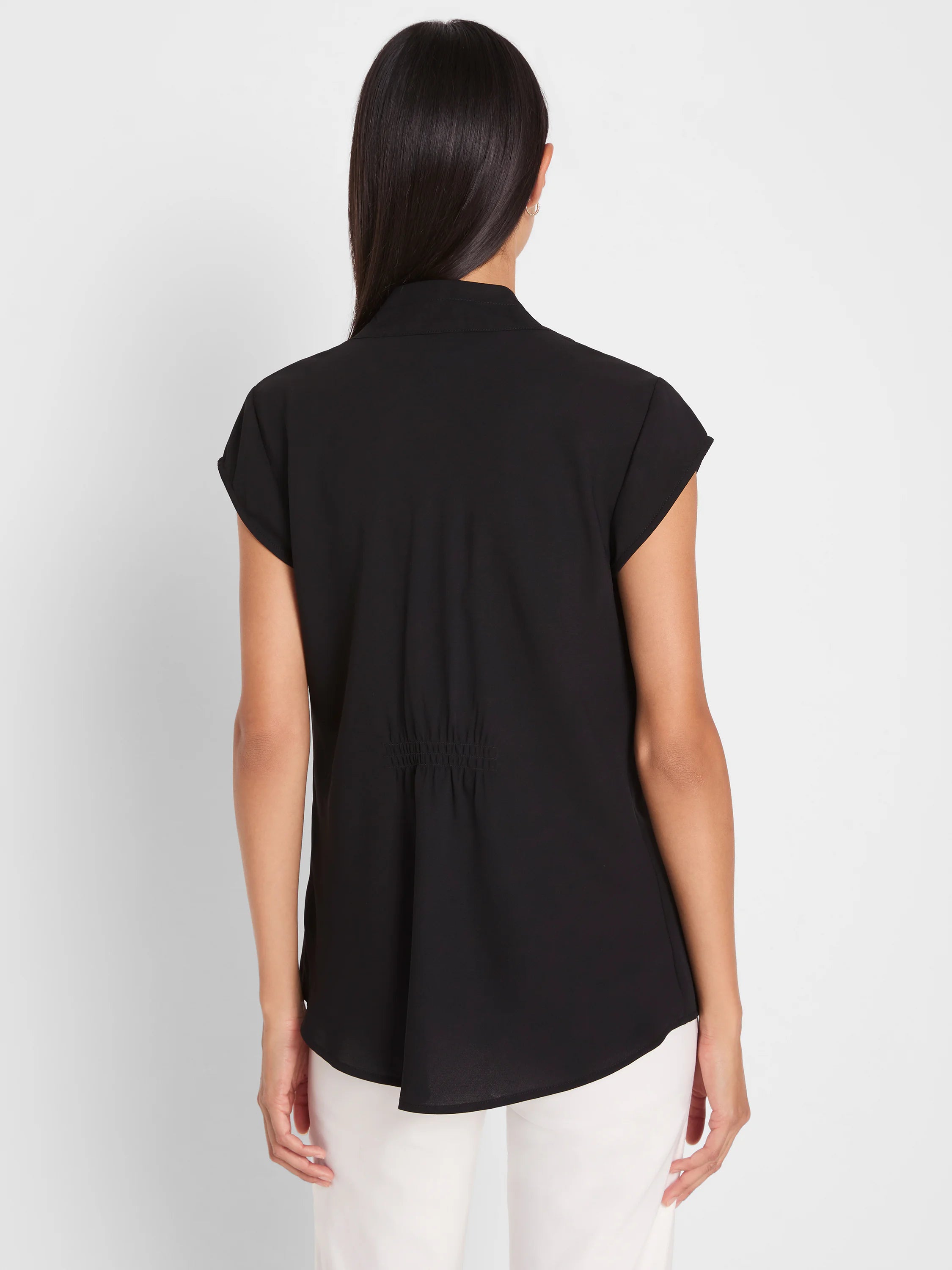 Black cap sleeve top, back view, with a gathered elastic waist detail and rounded hem.