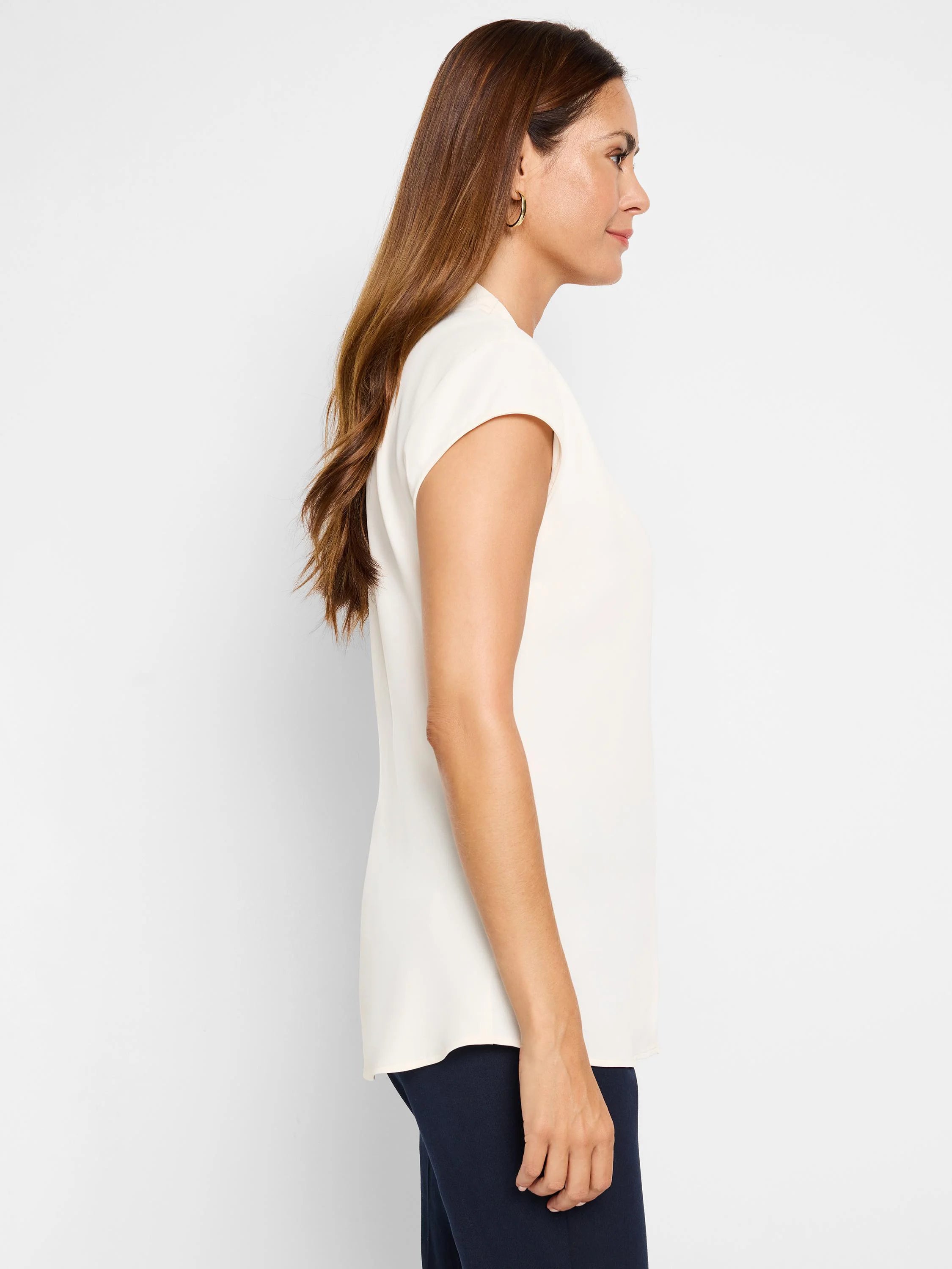 Ivory cap sleeve top with a relaxed, flowing fit, shown on a model in profile.