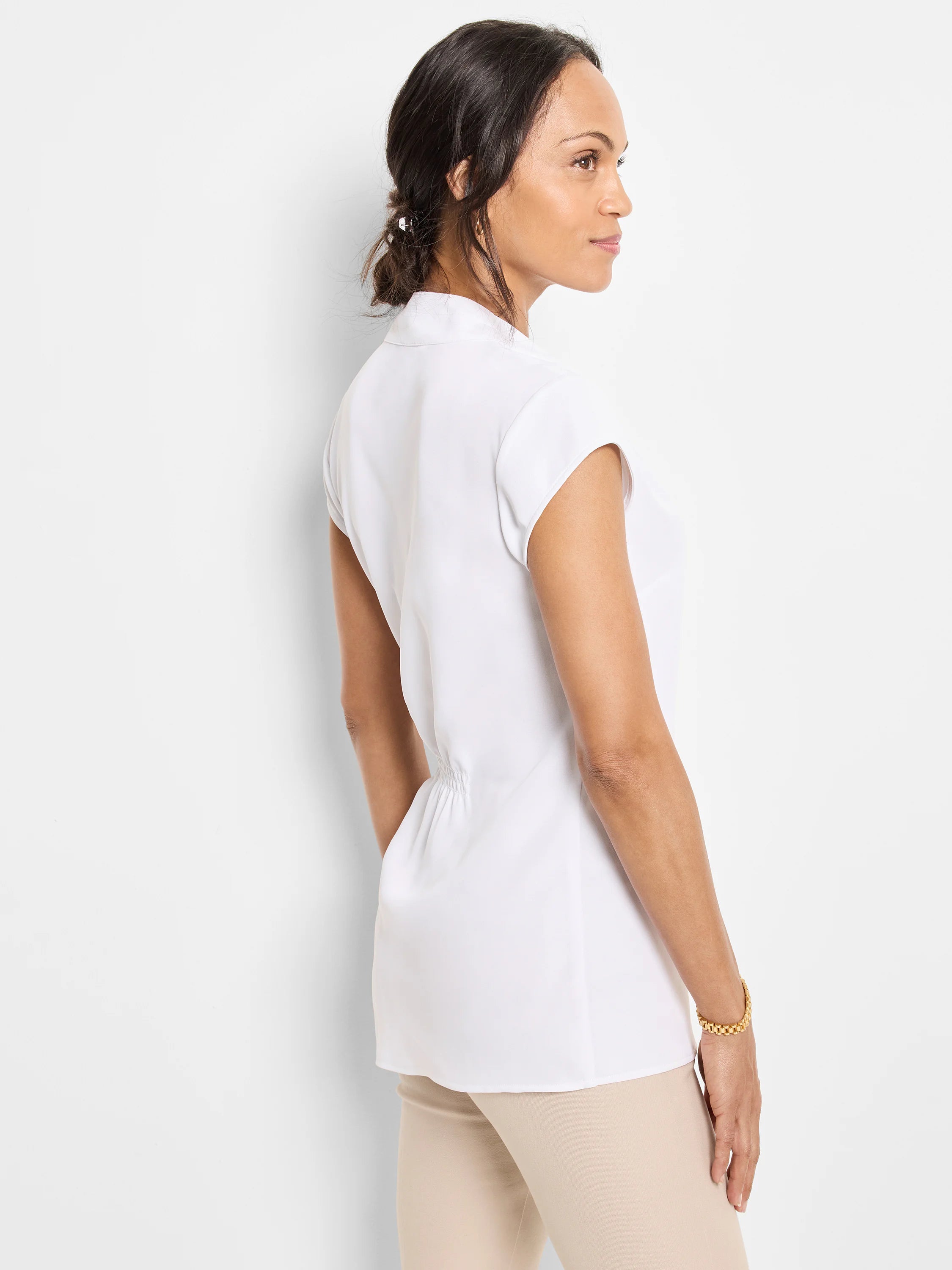 White cap-sleeve top with banded collar, back waist ruching, and tunic length.