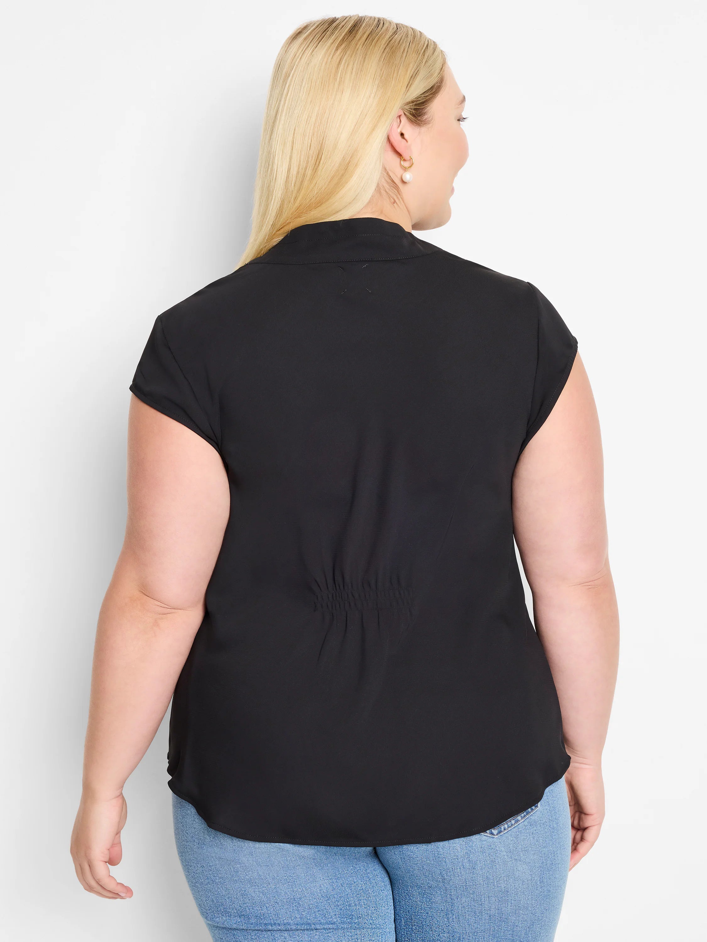 Black cap sleeve top, back view. Features a high collar, shirred mid-back detail, and a curved hem.