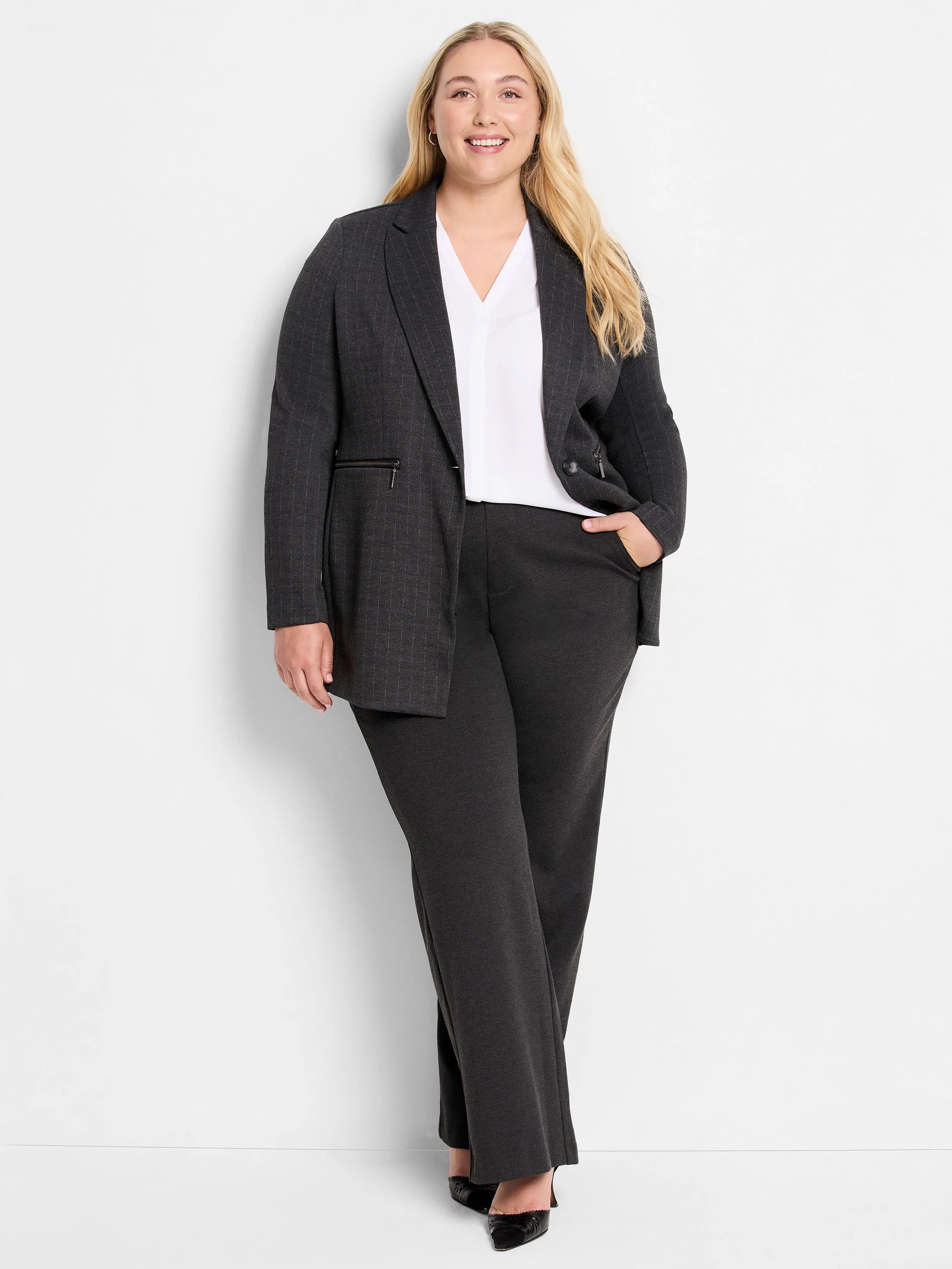 White cap sleeve V-neck top, worn layered under a dark gray pinstripe blazer.