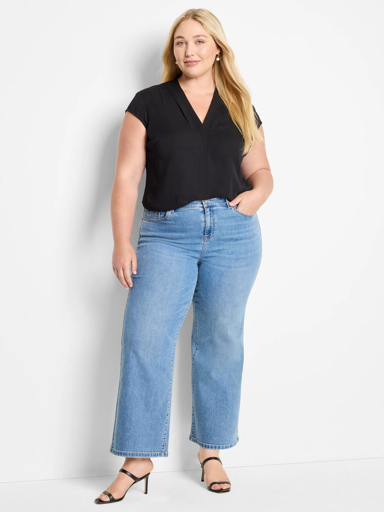 Black cap-sleeve blouse, V-neck.  Model wears light-wash, wide-leg jeans and black heels.