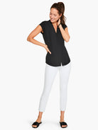 Black cap-sleeve top, V-neckline.  Model wears white pants and black sandals.