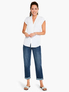 White cap-sleeve top with V-neck, shown on model with blue jeans and white sandals.