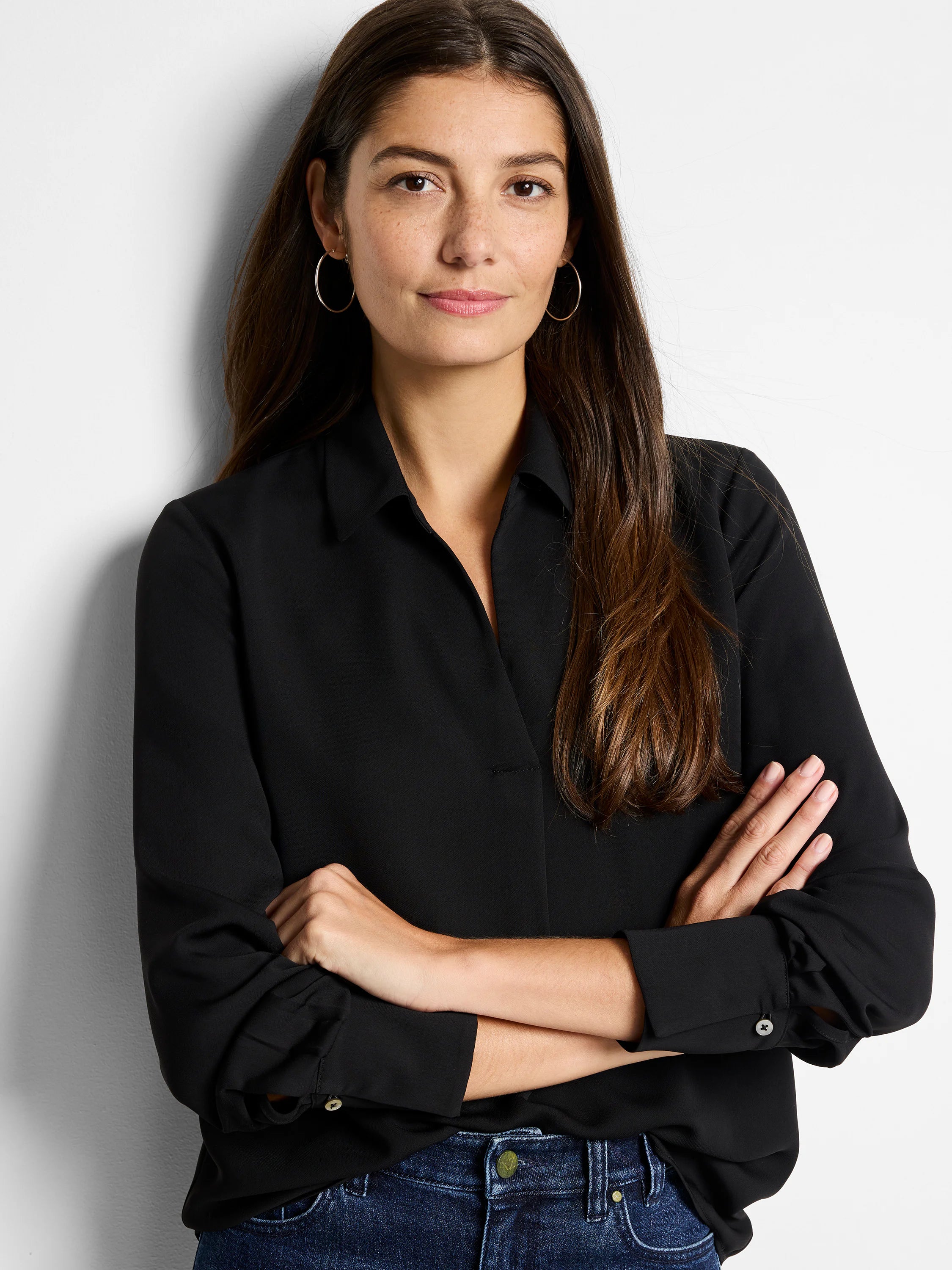 Black popover shirt with a classic collar, open neckline, and long sleeves with buttoned cuffs. Loose fit.