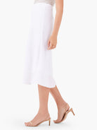 White midi linen slip skirt, with a subtly textured fabric and flowing drape.