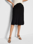 Black A-line linen slip skirt, mid-length.  Shown on a model.