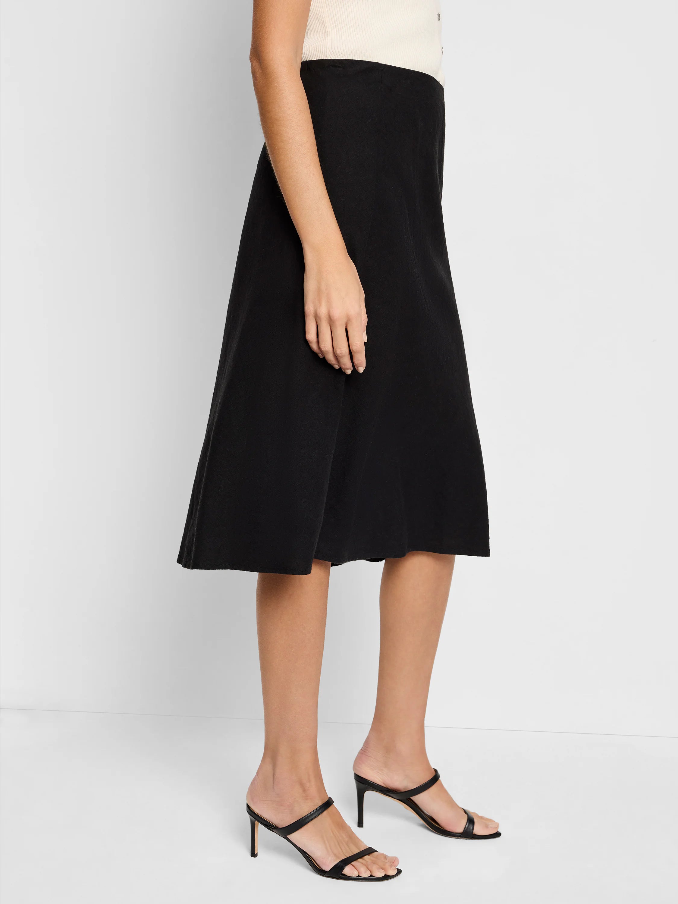 Black A-line linen midi skirt.  Shown on a model.