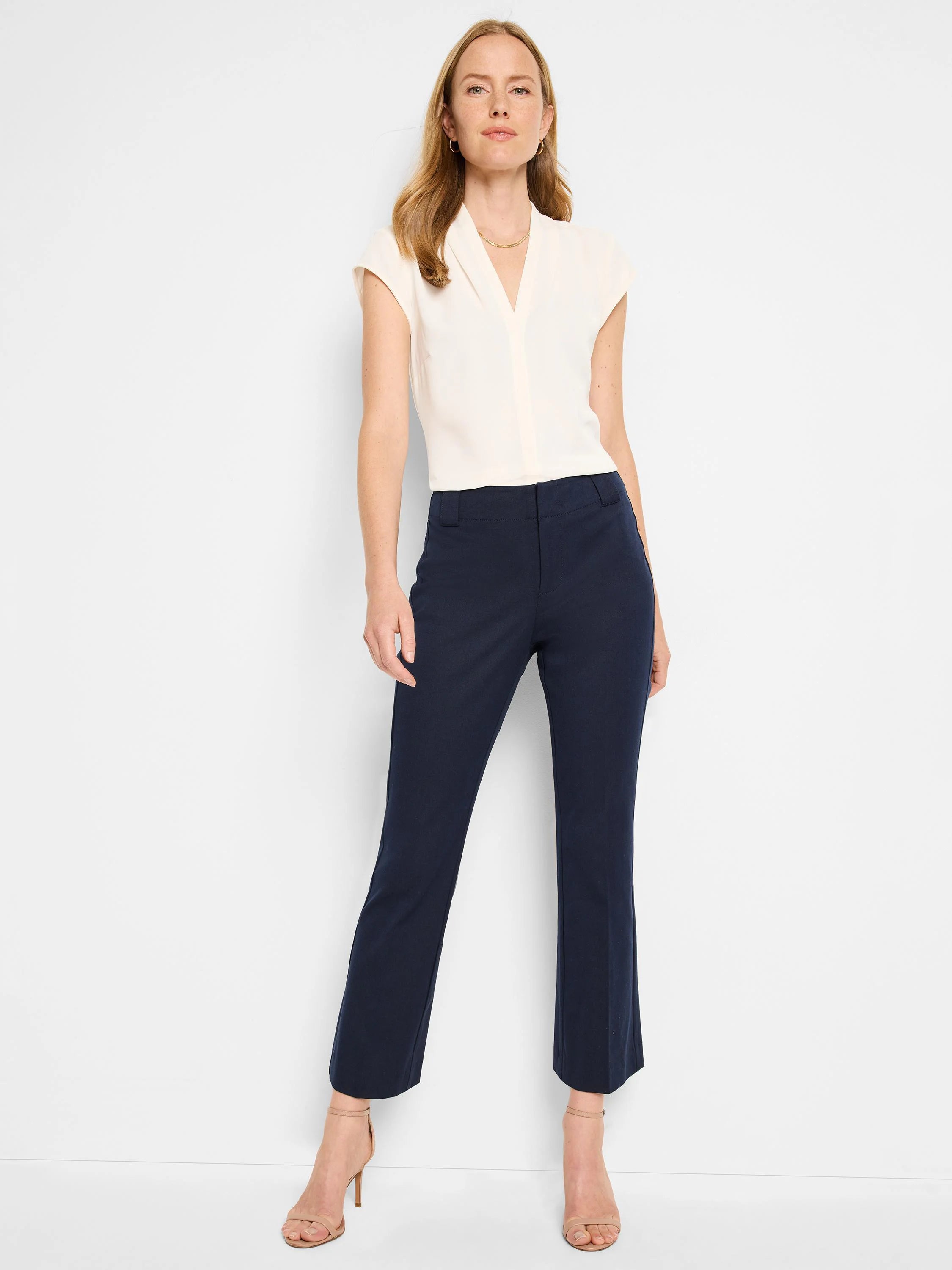 Navy demi bootcut pants, cropped just above the ankle. The tailored pants have a smooth dark blue fabric.