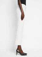 White pants: slim through the leg, cropped at the ankle, with a subtle demi boot flare. Worn on a model.