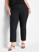Black tailored bi-stretch pants on model. Cropped length with a straight-leg and flat front.