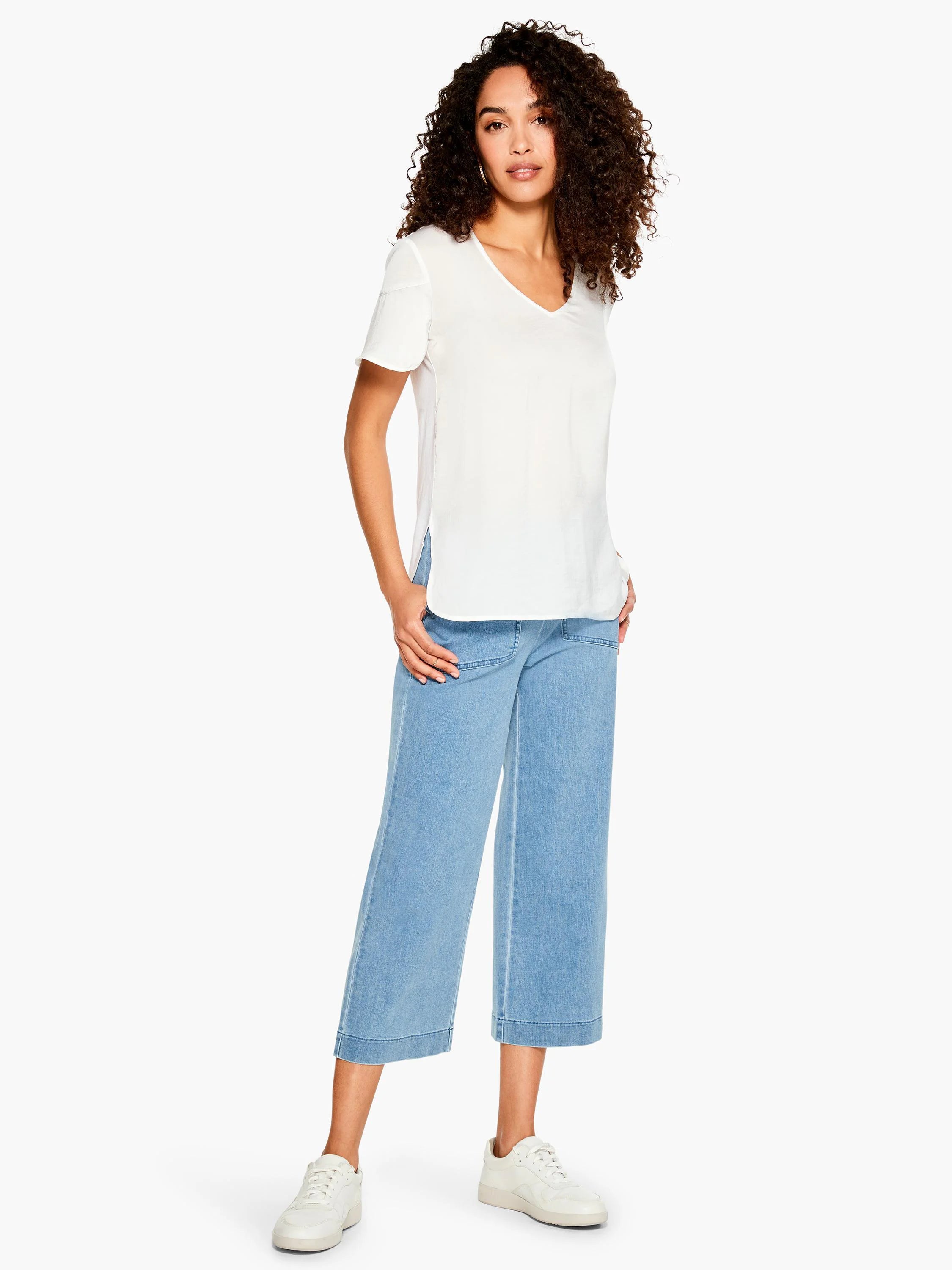 Light blue, wide-leg cropped jeans; model wears white top and shoes.