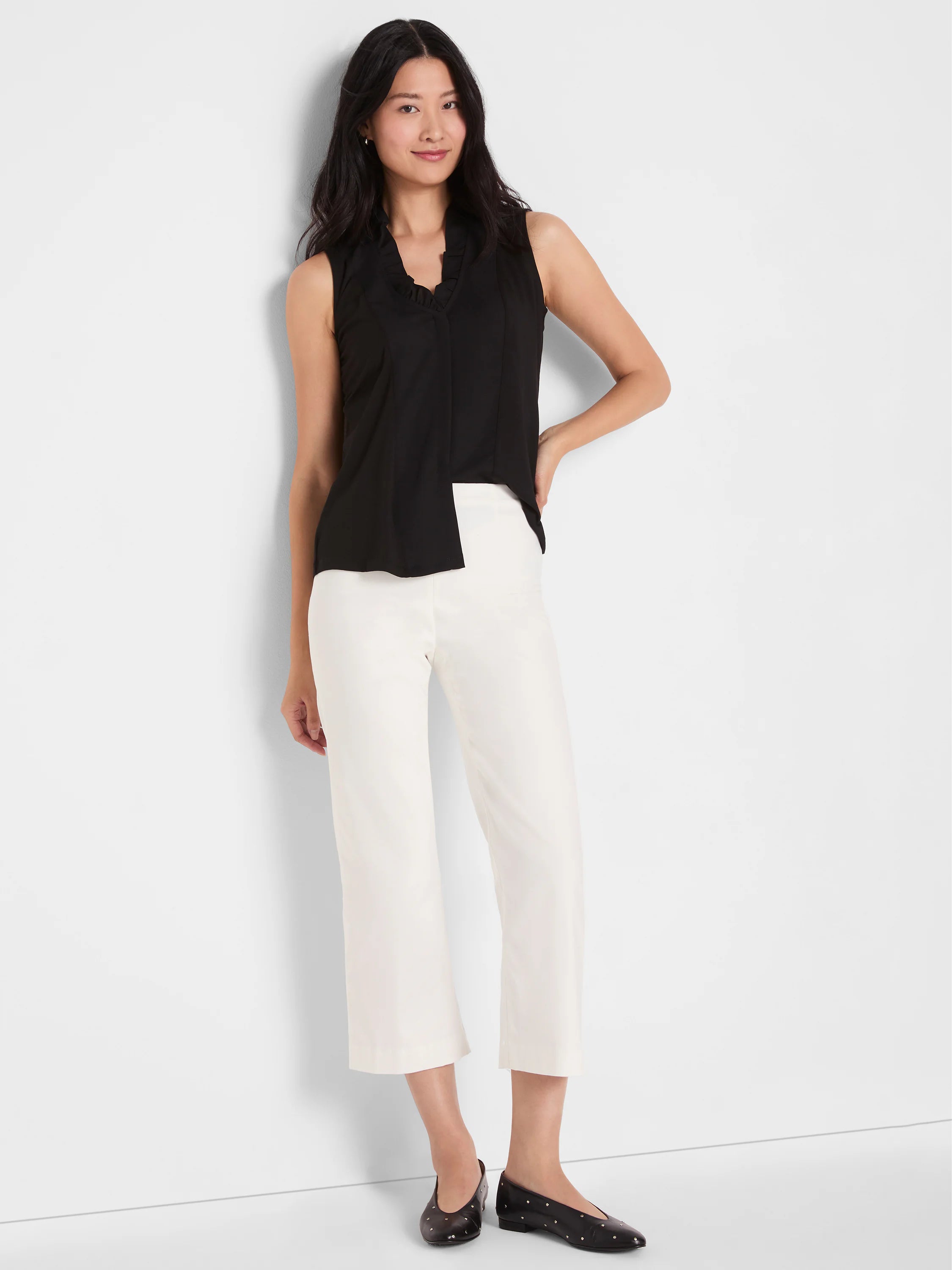 Cream wide-leg crop pants on a model, ending above the ankles.