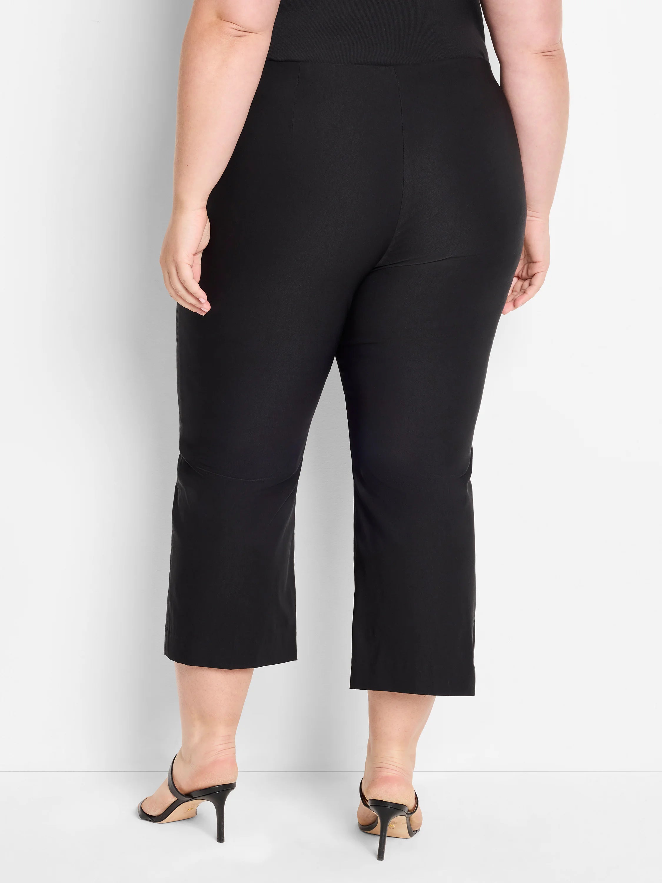 Black wide-leg crop pants shown from behind. Smooth fabric, cropped above the ankle.