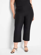Black polished wide-leg crop pants, shown on a model. Pants end at mid-calf.