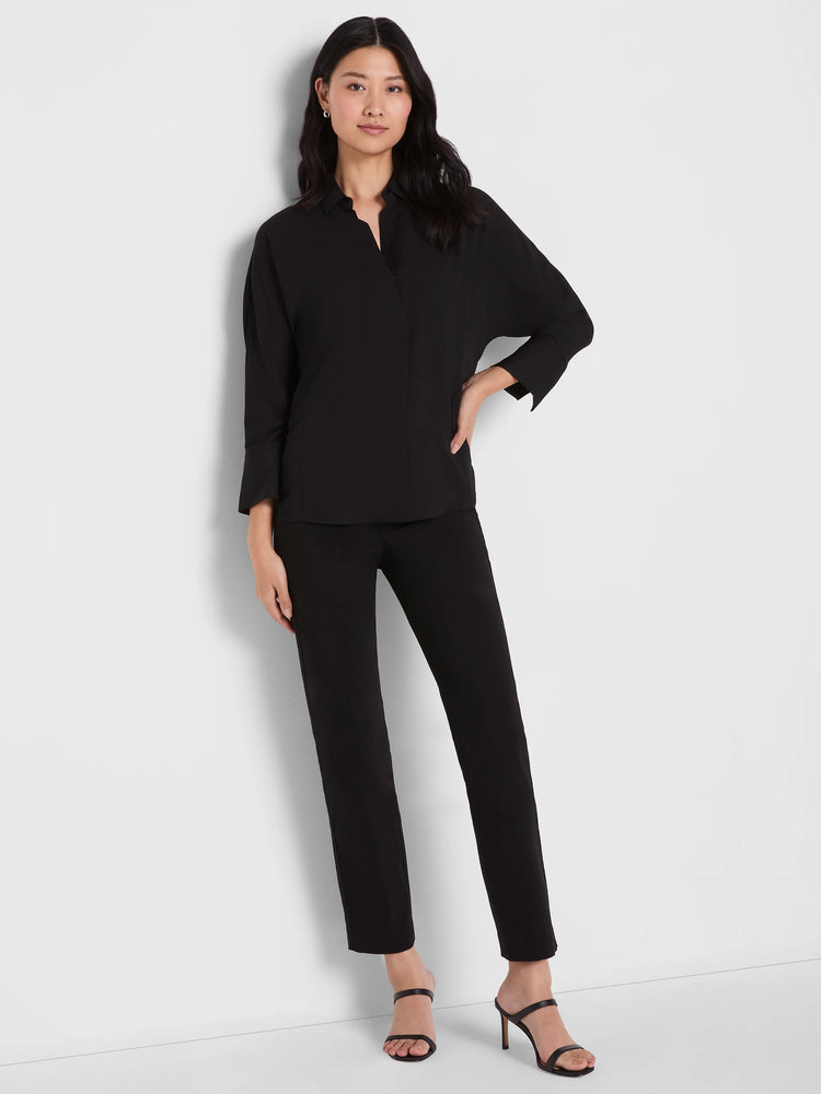 Black straight leg pants on a model. They feature a smooth fabric and extend to an ankle length.
