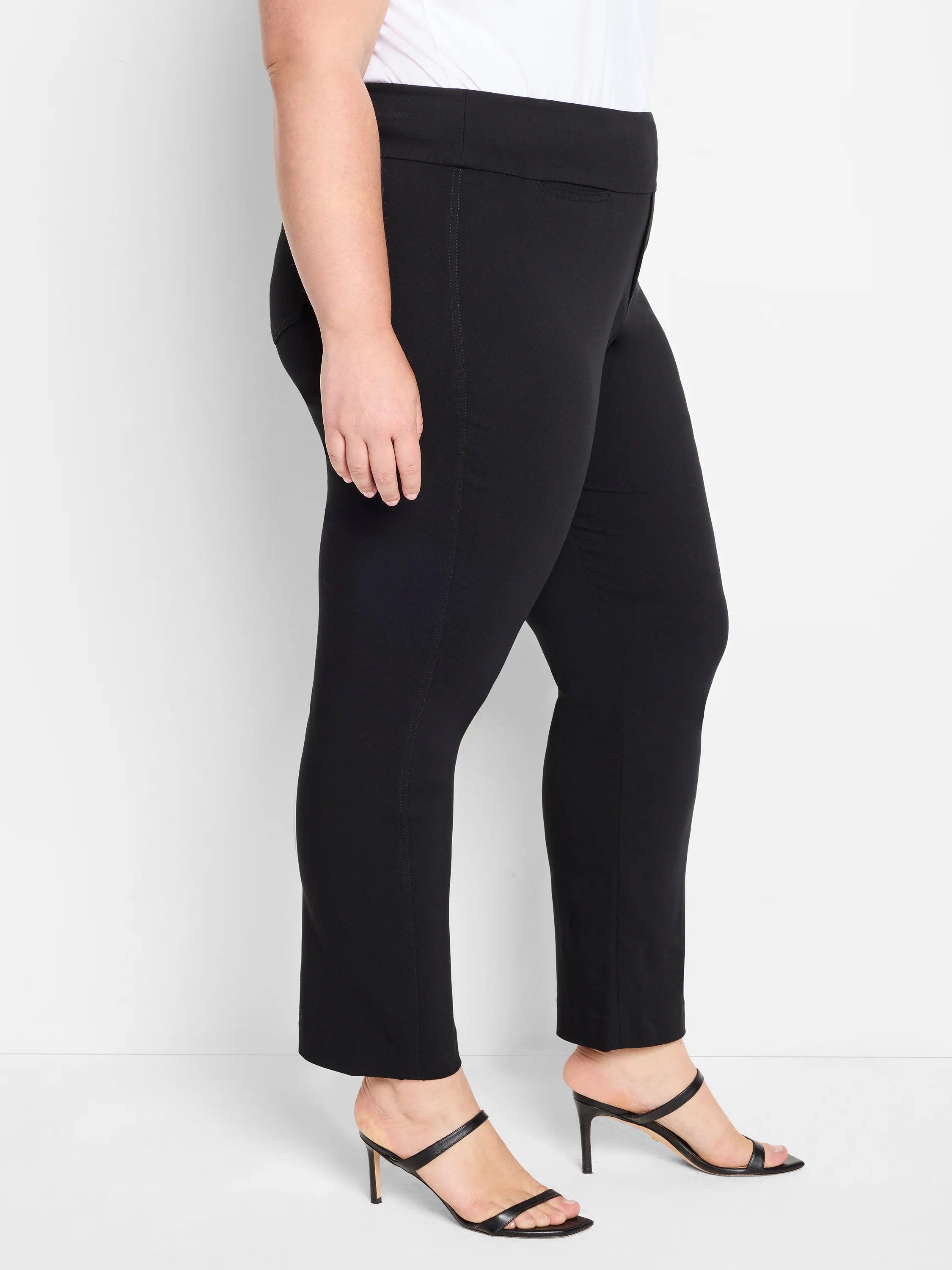 Black straight-leg pants on a model. Features a flat front and subtle horizontal hip pockets.