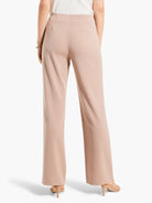 Pale beige wide leg trousers, high-waisted with smooth fabric, shown on model from behind.