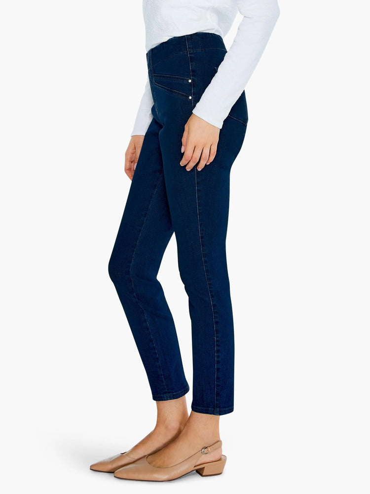 Dark blue slim jeans, high-waisted and ankle-length. Features visible stitching and two silver-toned studs at the hip.