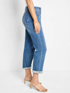 Medium blue mid-rise girlfriend jeans, relaxed fit, cuffed ankles, faded wash.