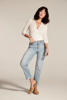 Light wash, mid-rise girlfriend jeans, cuffed at the ankles, worn by a model.