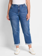 Medium blue mid-rise girlfriend jeans, faded at thighs, with a copper button closure and double-rolled cuffed hems.