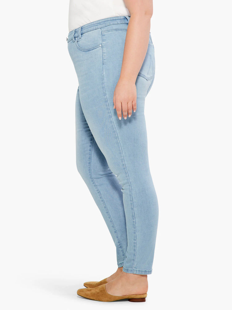 Light blue, slim-fitting ankle jeans shown on a model from the side.  Mid-rise.