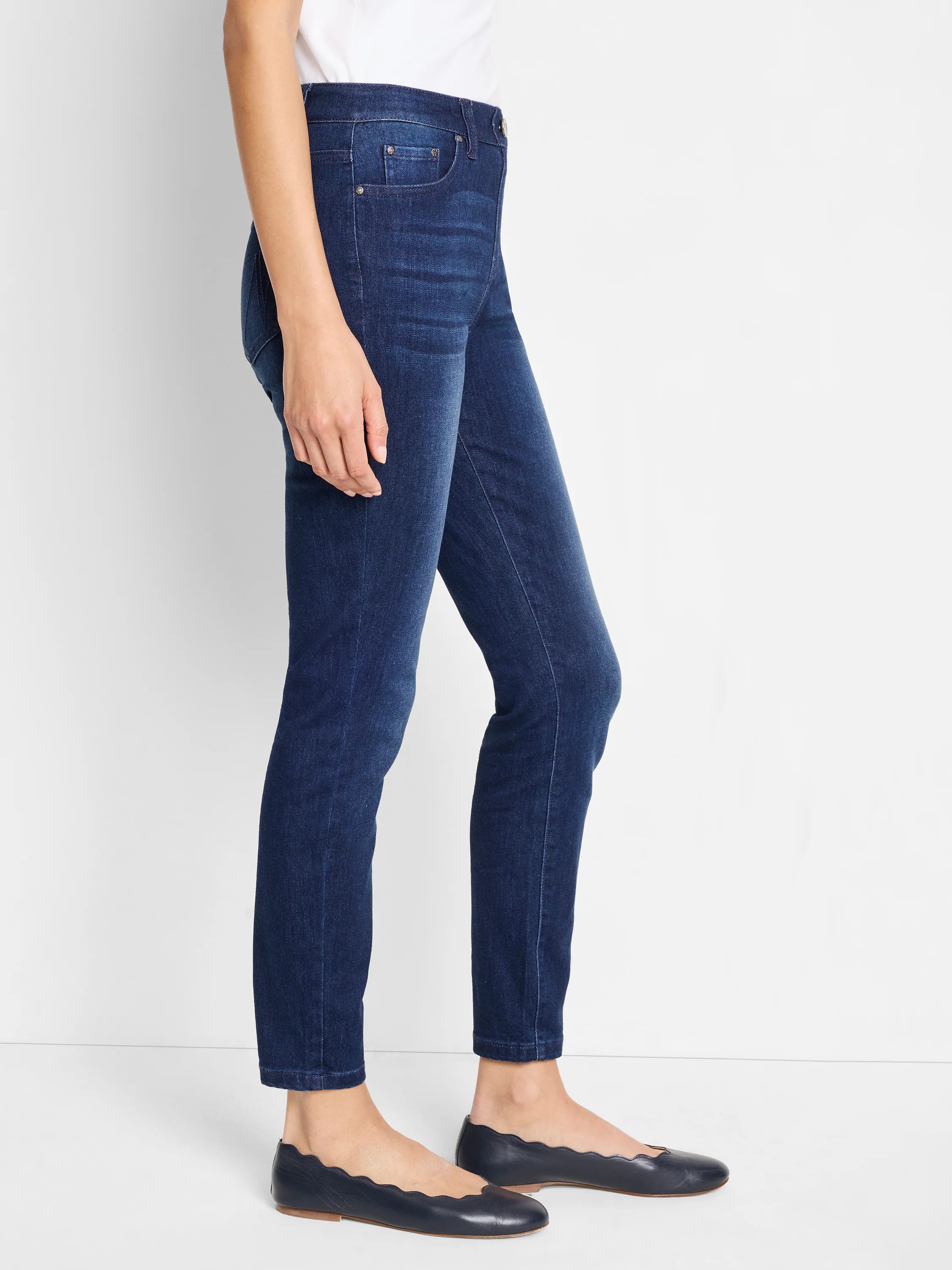 Dark wash, slim-fitting ankle jeans; mid-rise.  Shown on model with dark flats.