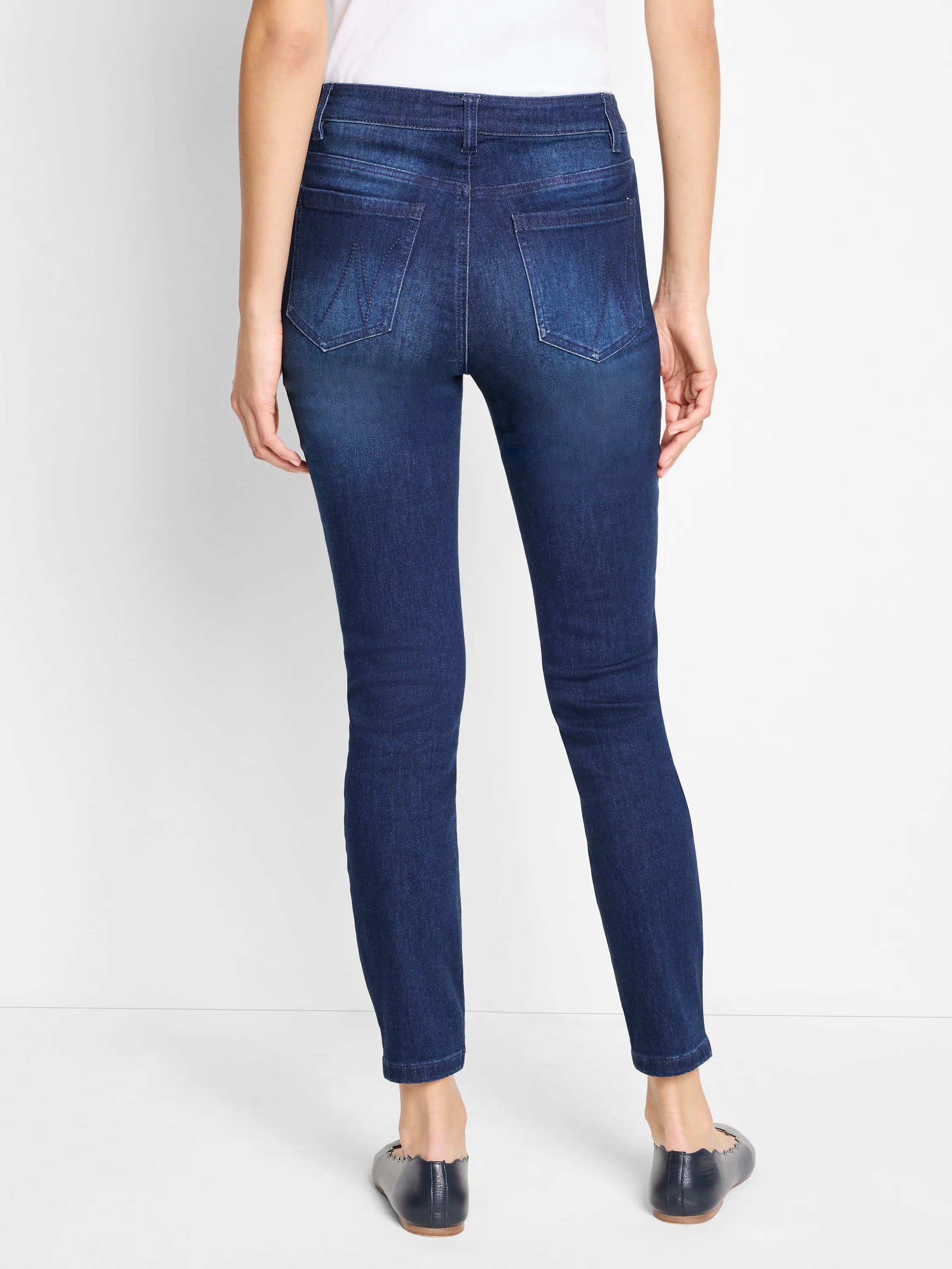 Dark wash, slim-fitting ankle jeans; mid-rise. Back view.