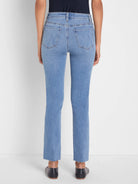 Back view of light blue straight ankle jeans with frayed hems and stitched back pockets featuring a subtle W design.