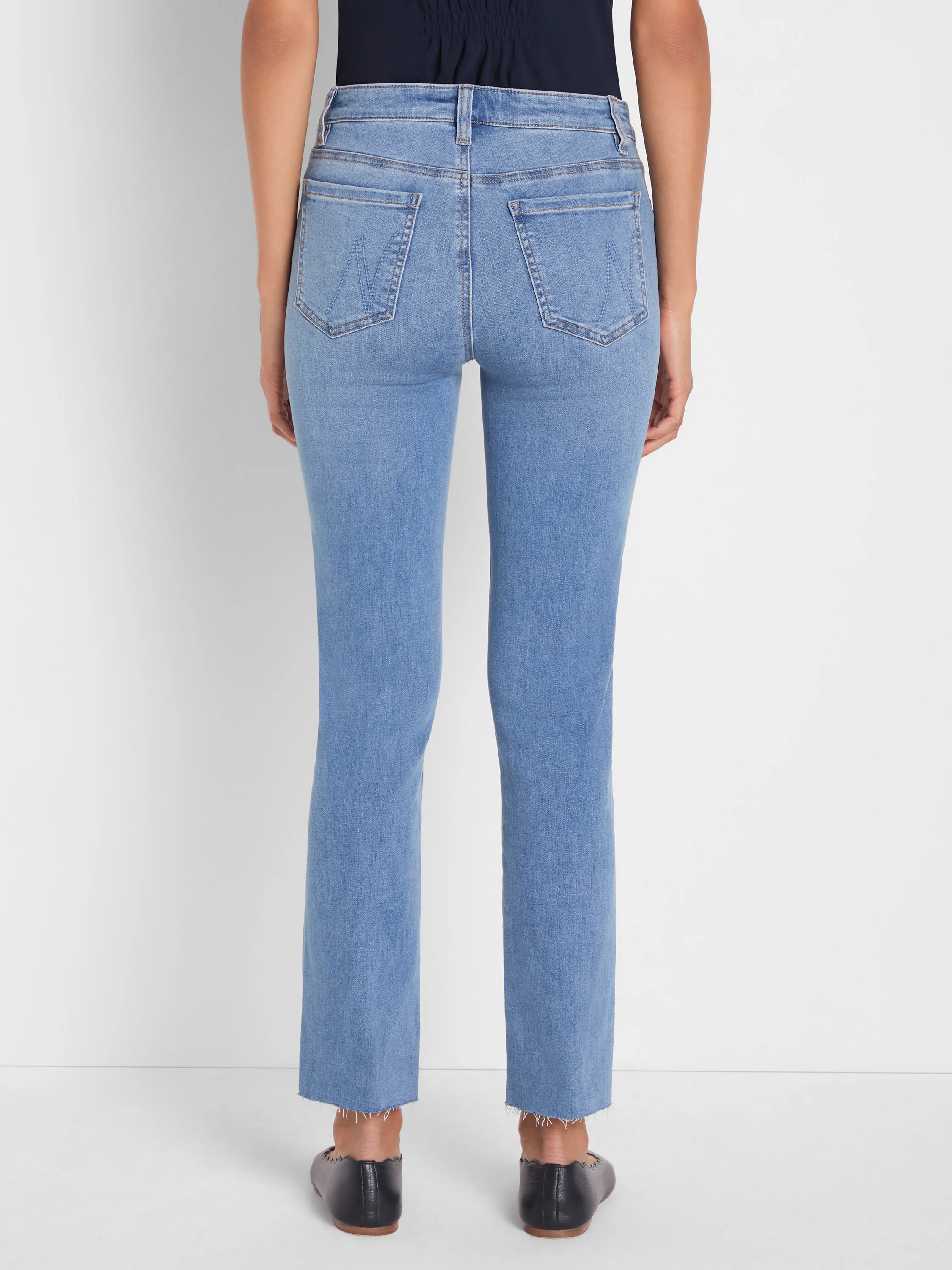 Back view of light blue straight ankle jeans with frayed hems and stitched back pockets featuring a subtle W design.