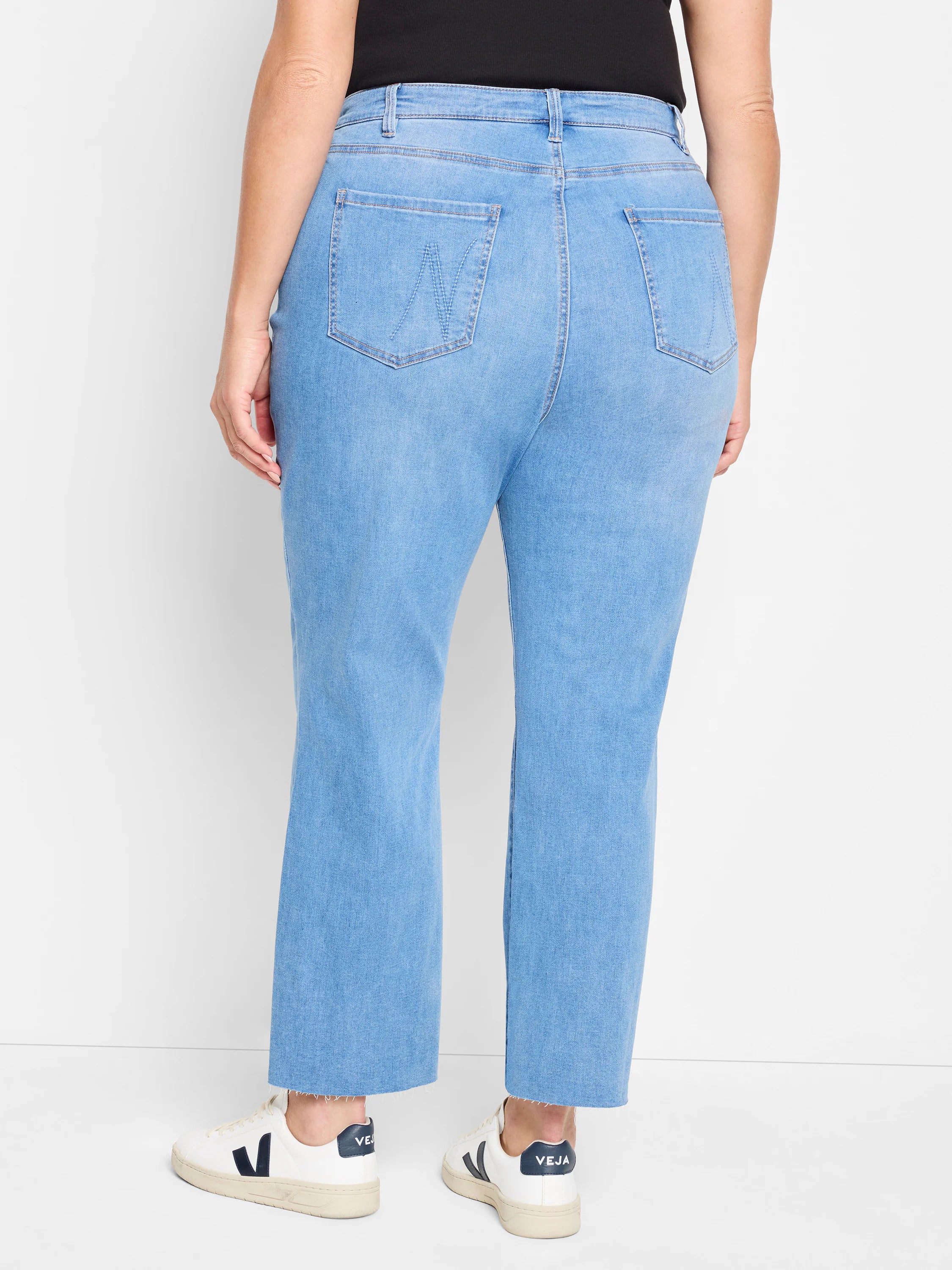 Light blue straight ankle jeans with raw hems. Back view shows pockets with "W" shaped decorative stitching.