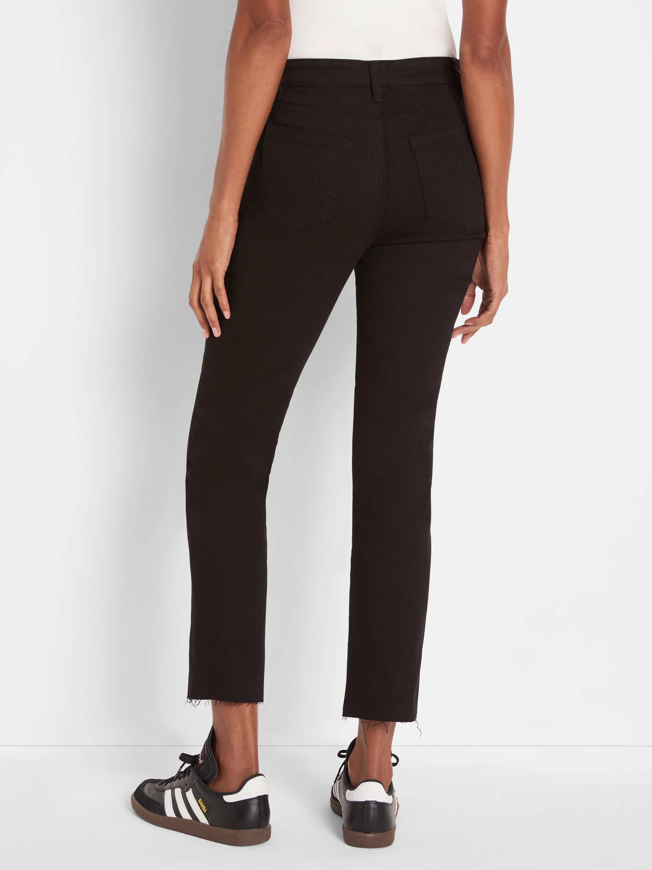 Black straight ankle jeans on a model, shown from behind. Features frayed hems and visible back pockets.