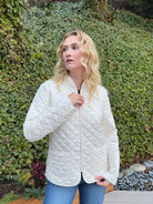 Off-white quilted short coat, diamond pattern, zipper closure, hip length, two patch pockets.