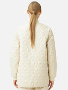 Off-white quilted jacket, diamond pattern, knit collar.  Rear view.