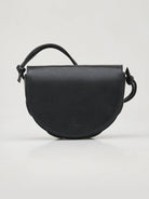 Black leather half-moon crossbody bag with knotted strap and subtle logo.