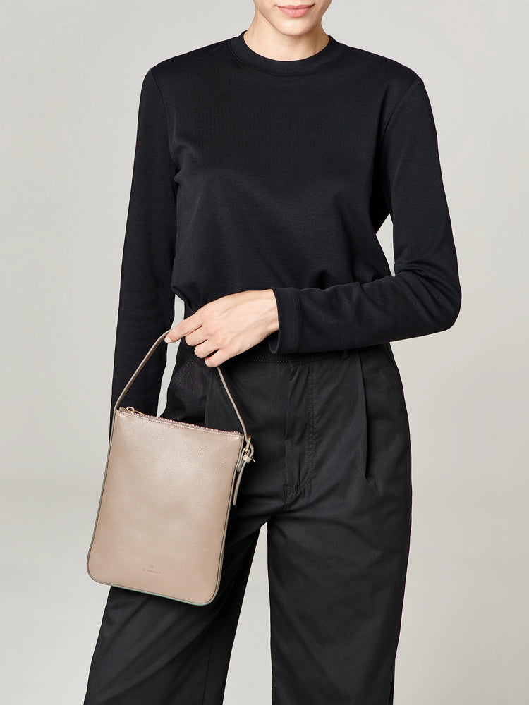 Beige rectangular crossbody bag with a top handle and zipper.  Subtle branding.