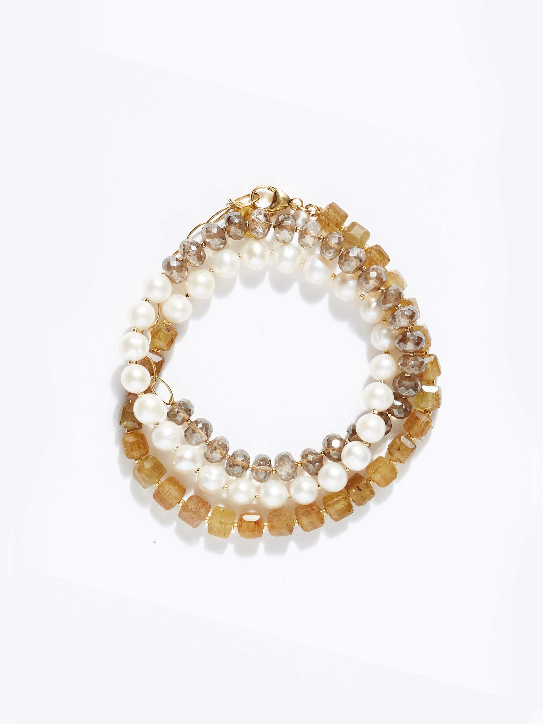 Triple wrap bracelet with gold clasp. Features white pearls, light brown, and darker brown faceted beads.