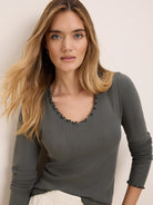 Dark grey-green pointelle rib long sleeve tee with ruffled V-neck and cuffs.