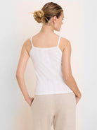 White pointelle rib cami, seen from back. Features delicate lace-trimmed spaghetti straps & scoop neckline.