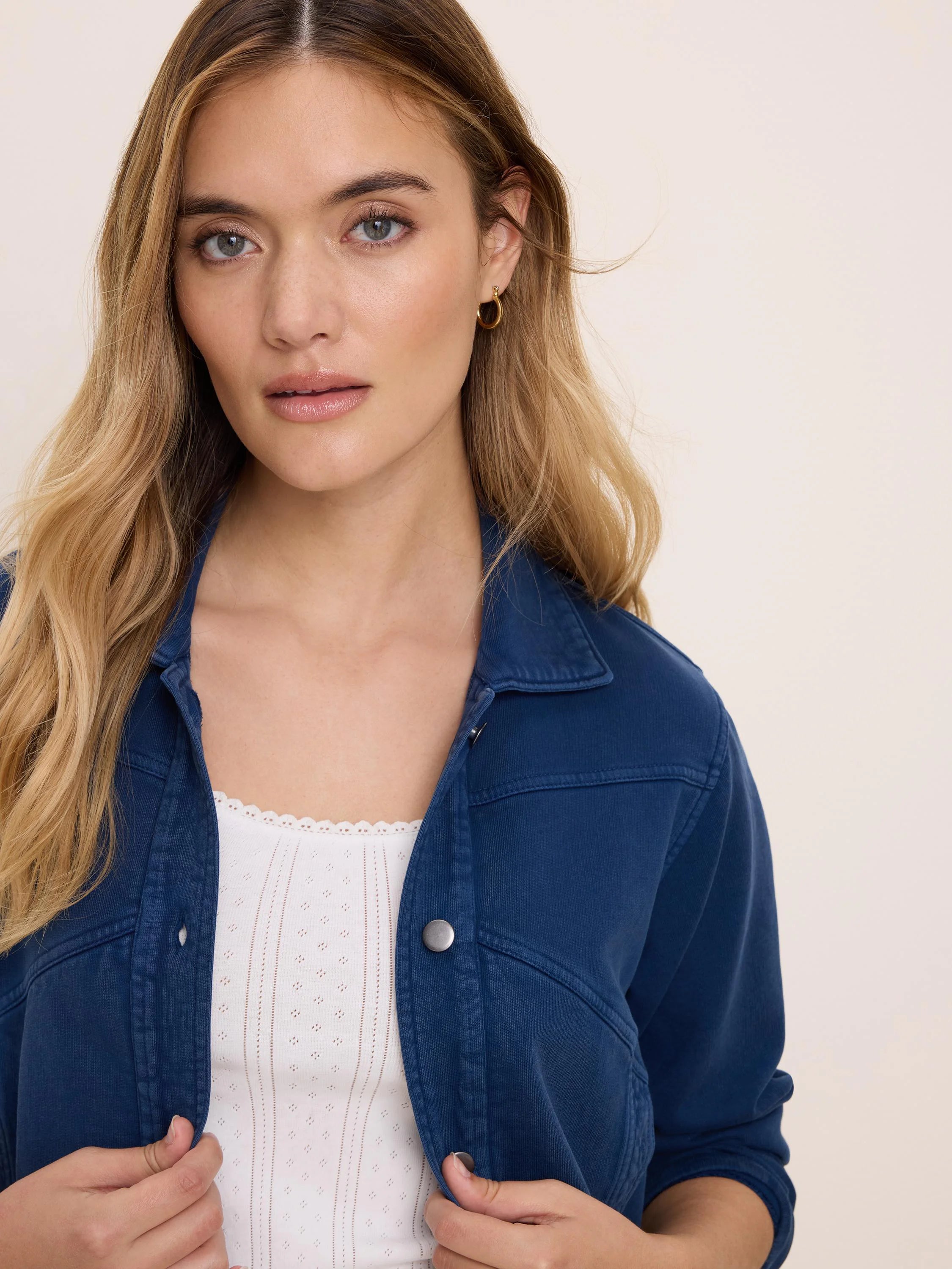 Navy blue terry collared jacket with silver snap buttons and visible seam details.