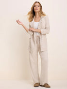 Oatmeal long French terry jacket with lapels, patch pockets, and raw edges.
