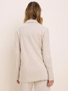Oatmeal French Terry long jacket on model from back. Features a collar, long sleeves, and a relaxed fit.