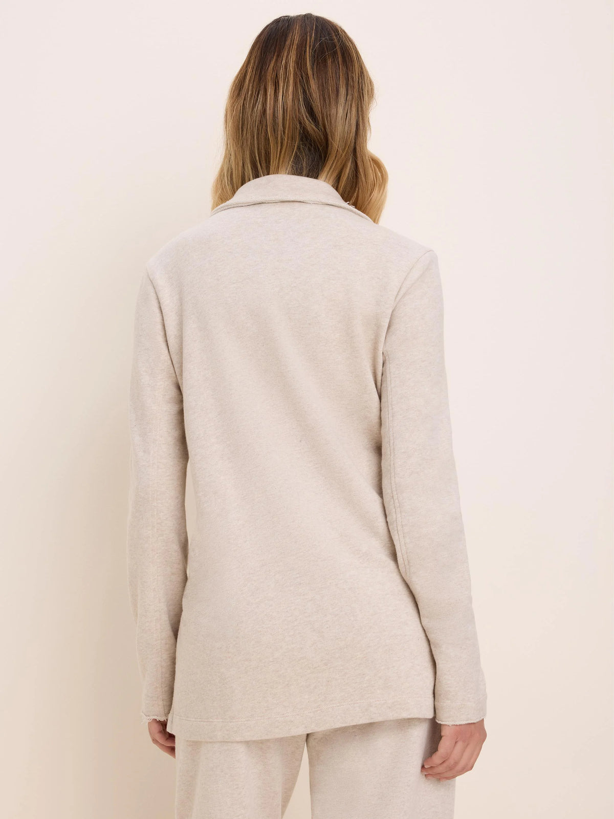 Oatmeal French Terry long jacket on model from back. Features a collar, long sleeves, and a relaxed fit.