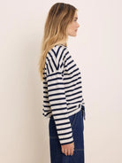 Long-sleeve tee with navy and off-white horizontal stripes, V-shaped at shoulders.